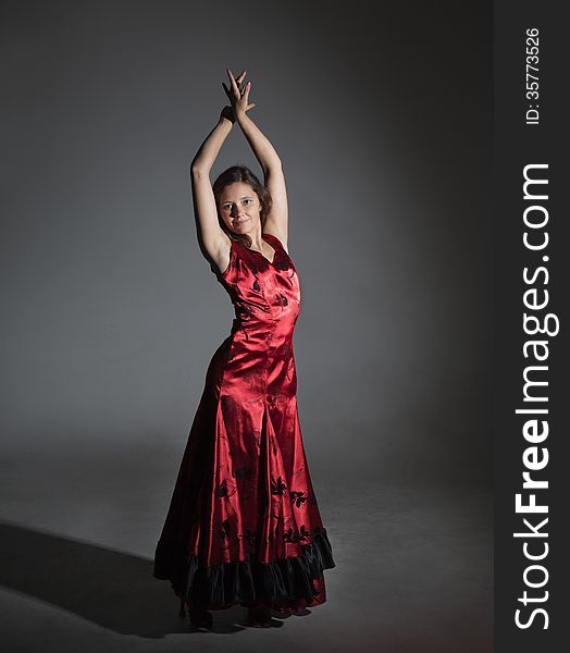 Young woman dancing flamenco, studio shot, gray background