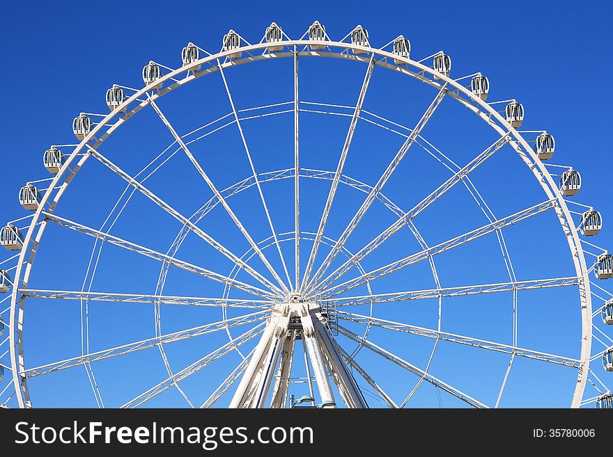 Closeup of big Ferris Wheel against blue sky