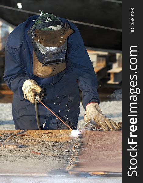 Welder at shipyard working on steel project. Welder at shipyard working on steel project