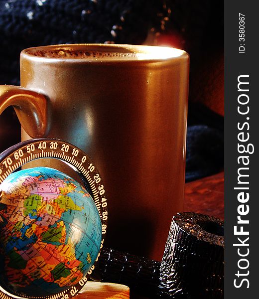 Brown cup with coffee by a little globe and smoking tube. Brown cup with coffee by a little globe and smoking tube