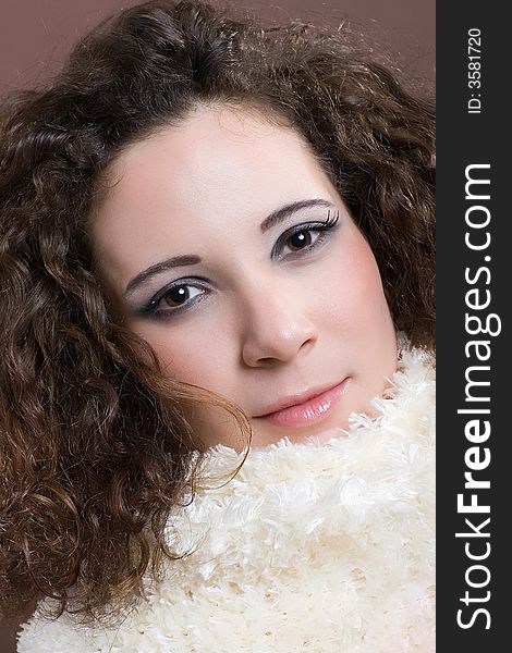 Attractive woman with fluffy scarf. Brown background. Attractive woman with fluffy scarf. Brown background.