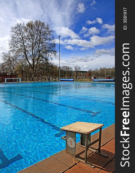 Bright blue image of school pool with starting block on a cloudy day. Bright blue image of school pool with starting block on a cloudy day.