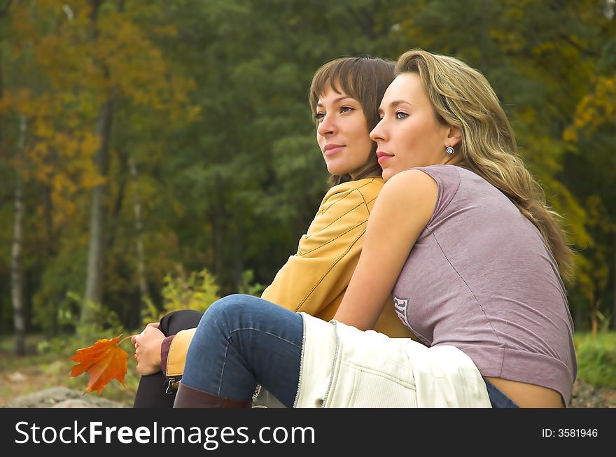 Two girls having a rest in autumn park. Two girls having a rest in autumn park