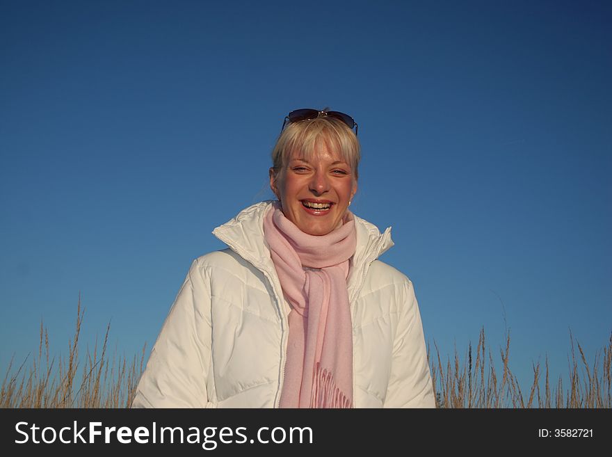 Portrait of a young attractive girl at autumn day on the blue sky background. Portrait of a young attractive girl at autumn day on the blue sky background