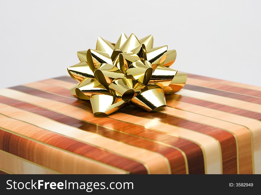 Christmas gift wrapped in gold and brown paper