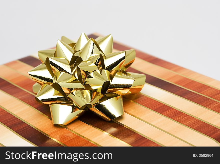 Christmas gift wrapped in gold and brown paper