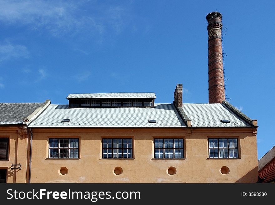 A building of a brewery with a tall chimney. A building of a brewery with a tall chimney