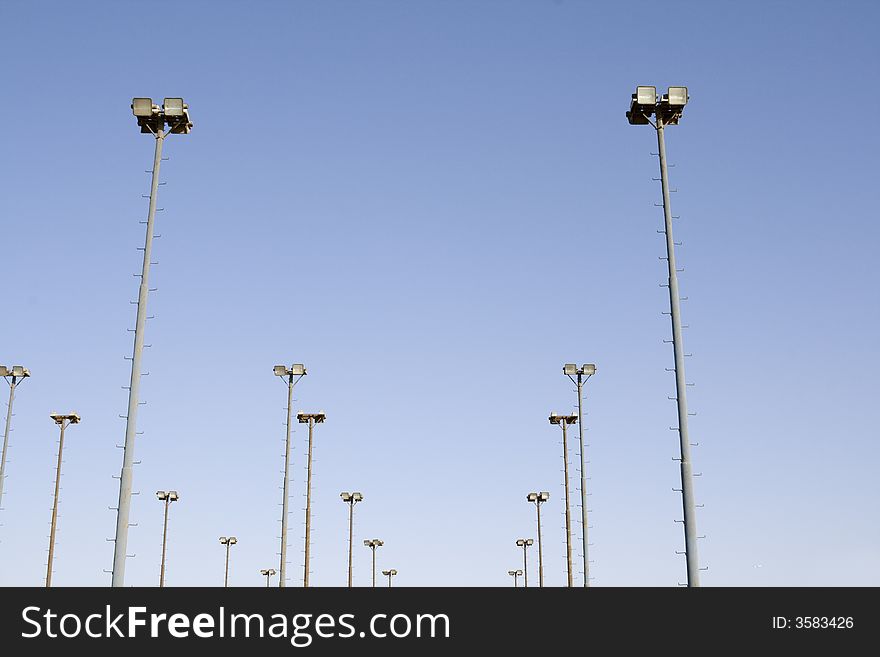 Several lamp posts which form the lighting for a stadium... Against blue background and clear sky. Several lamp posts which form the lighting for a stadium... Against blue background and clear sky...