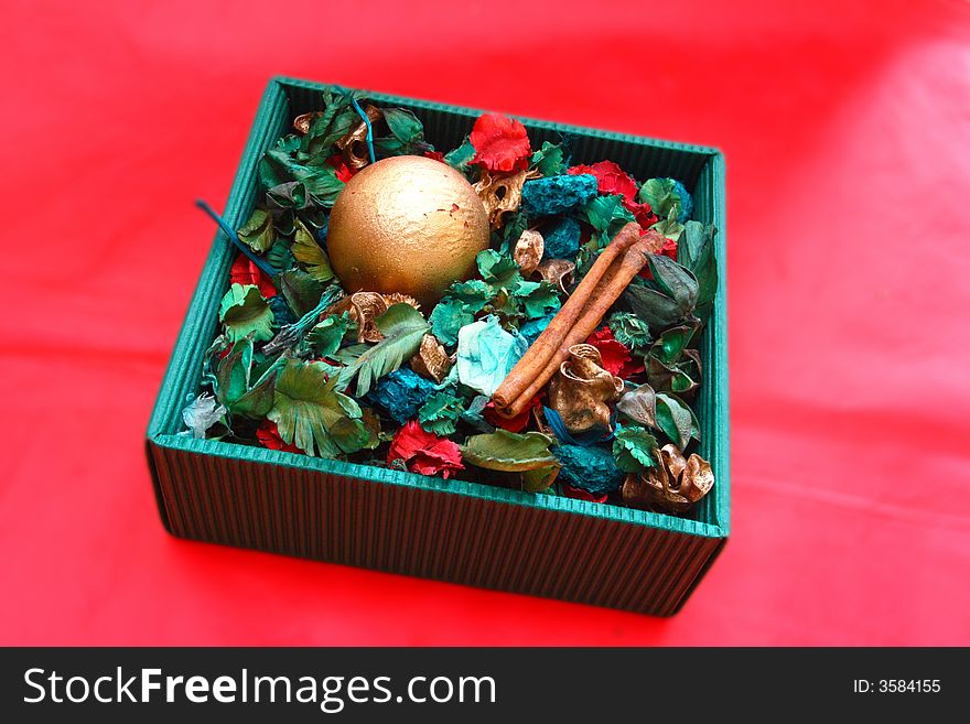 In a green box christmas decorations are on a red background