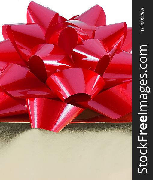 Christmas present wrapped with a large red bow on top, isolated on white