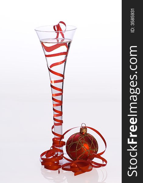 Glass of champagne decorated red ribbon and christmas ball