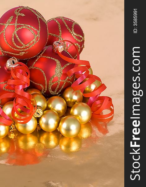 Christmas red and  gold  balls with ribbon on  the gold  background. Christmas red and  gold  balls with ribbon on  the gold  background