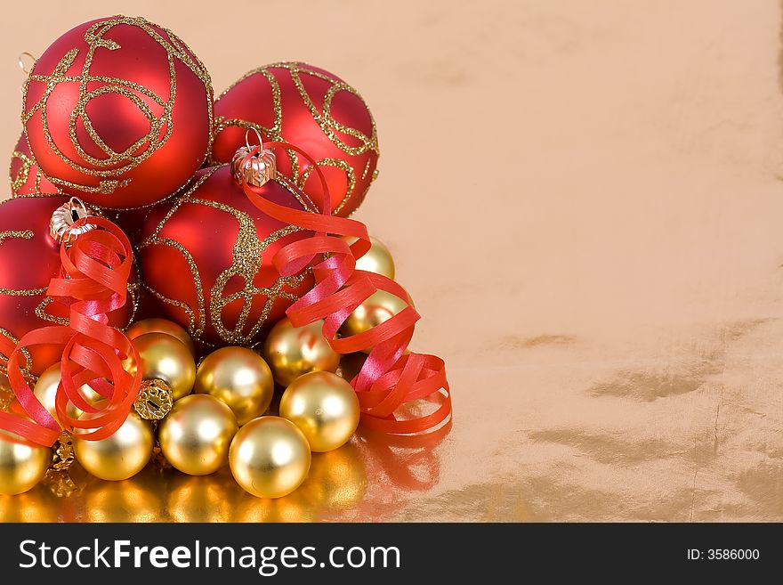 Christmas red and  gold  balls with ribbon on  the gold  background. Christmas red and  gold  balls with ribbon on  the gold  background