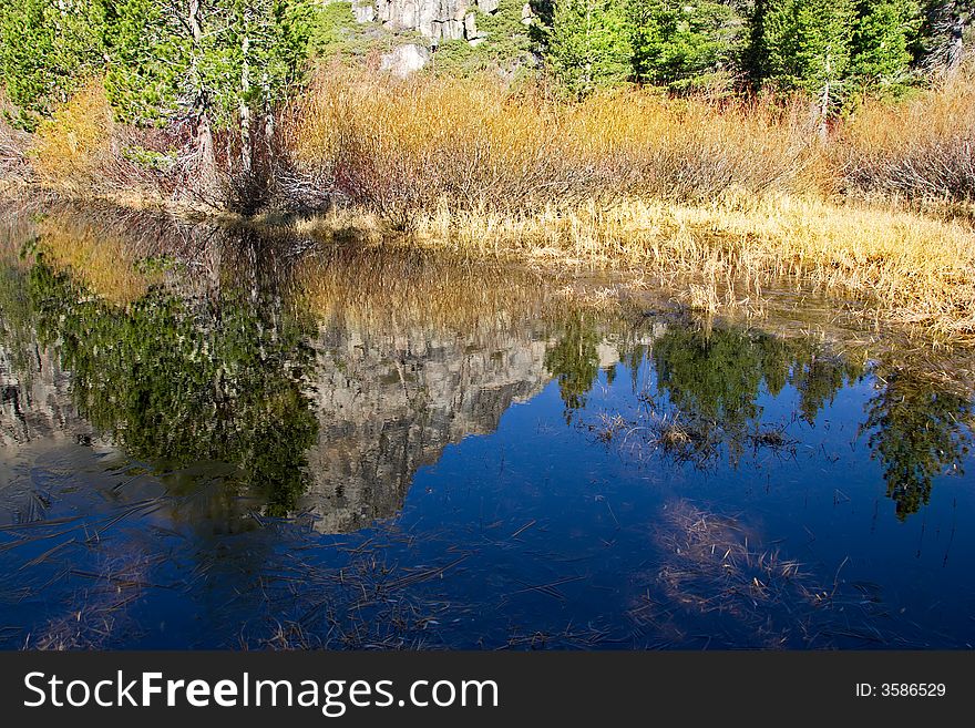 Reflection of rocky mountain in very blue water pond. Reflection of rocky mountain in very blue water pond