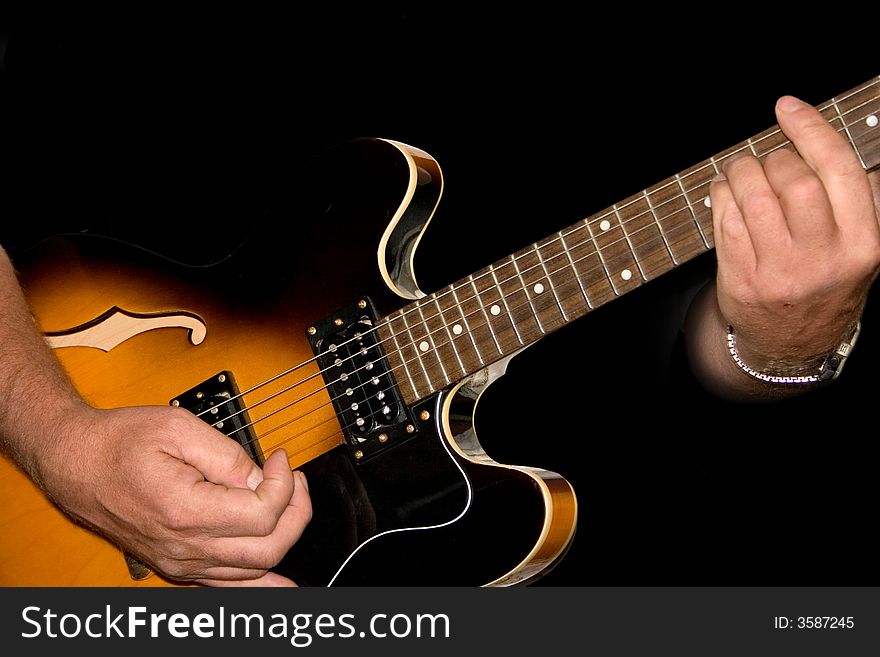 Hands planing a guitar on a black background. Hands planing a guitar on a black background