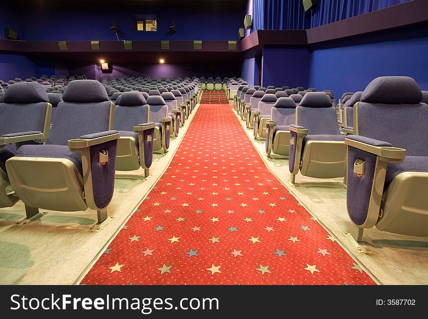 Empty cinema auditorium with blue chairs