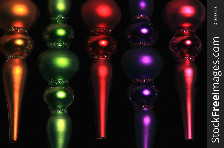 Colorful glass christmas ornaments on black background