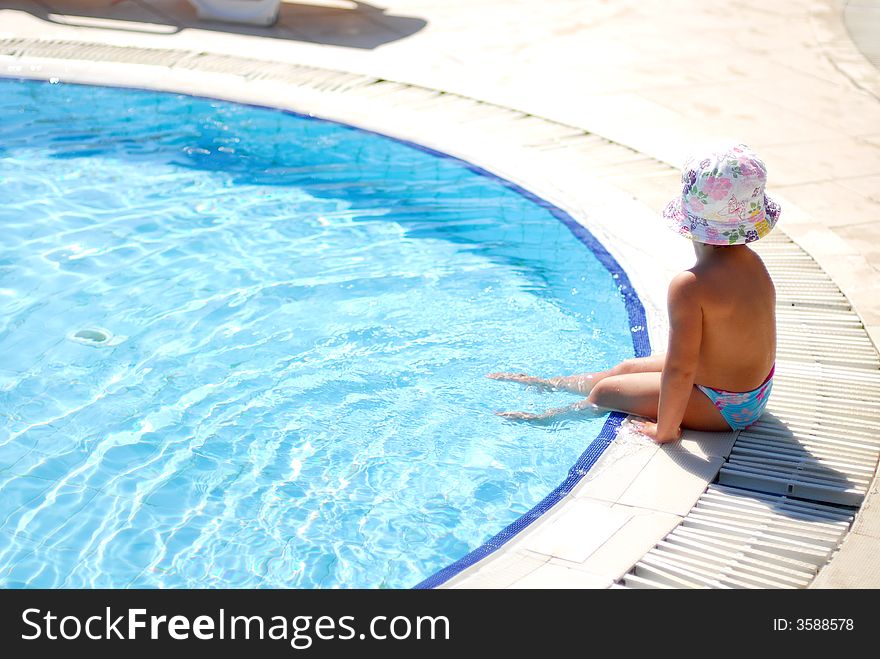 The little girl has a rest near pool. The little girl has a rest near pool