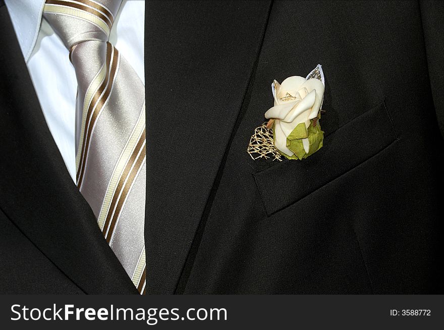 An image of black suit with flower. An image of black suit with flower