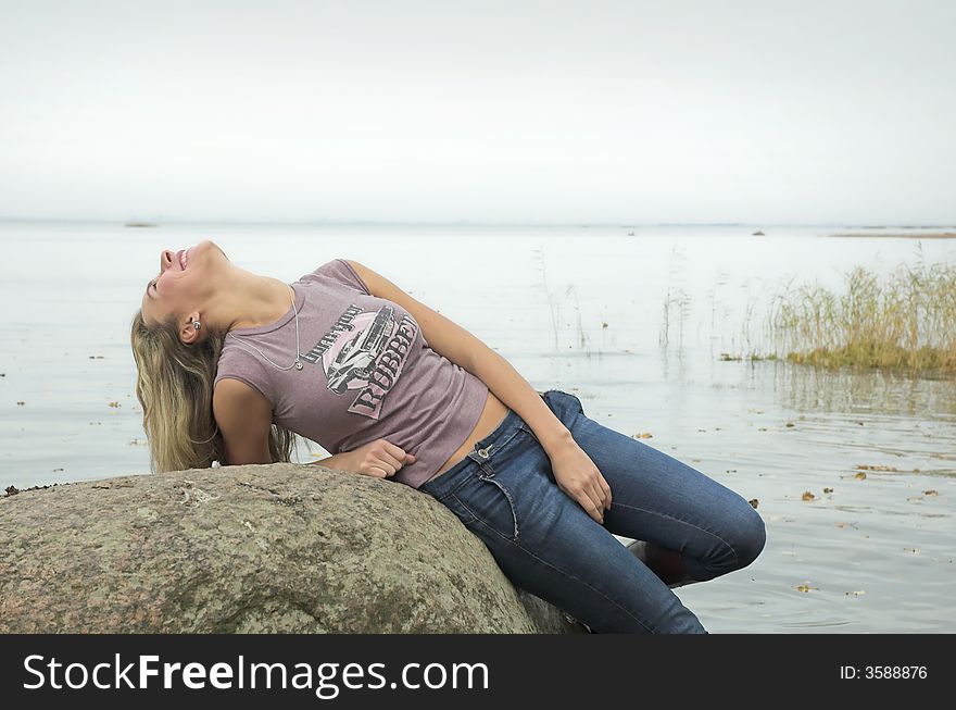 The beautiful girl has a rest on coast