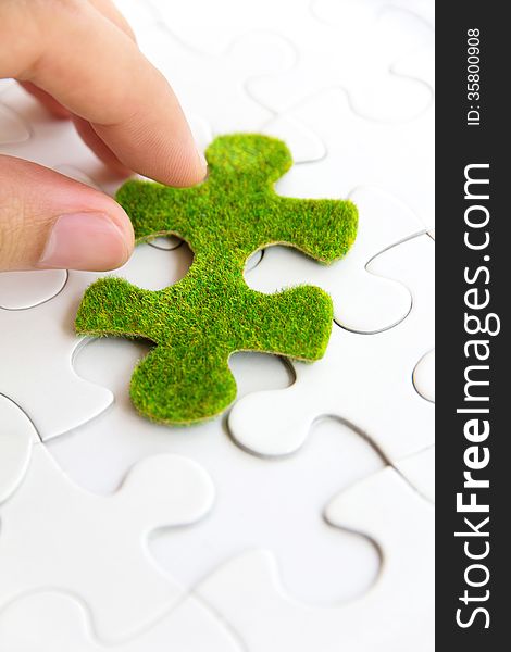 Hand Holding A Green Puzzle Piece