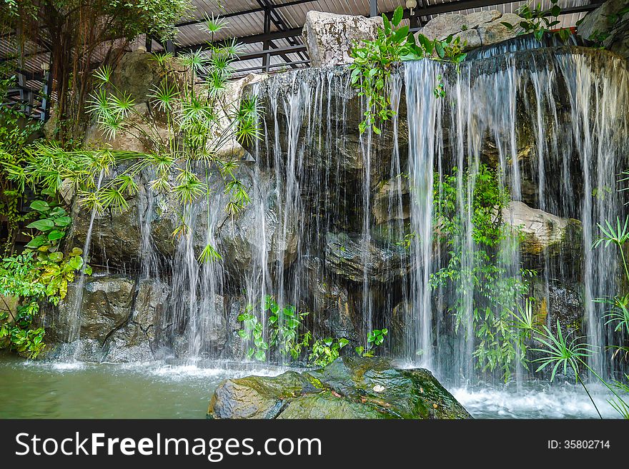 Decorative, landscaped waterfall in the home garden.