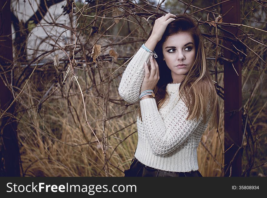 Young woman portrait with silver jewelary on hand in white sweater. Young woman portrait with silver jewelary on hand in white sweater