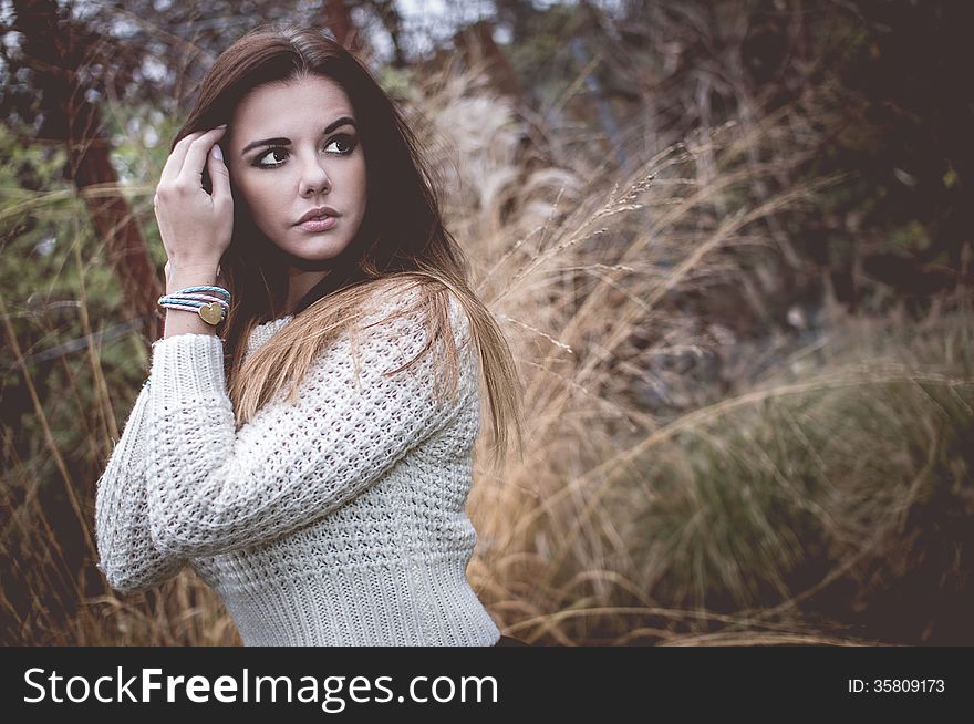 Young woman with silver jewelary on hand in white sweater. Young woman with silver jewelary on hand in white sweater