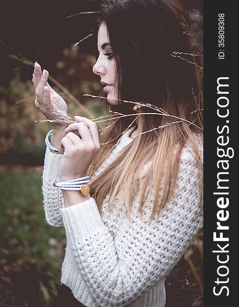 Young woman with silver jewelary on hand in white sweater. Young woman with silver jewelary on hand in white sweater