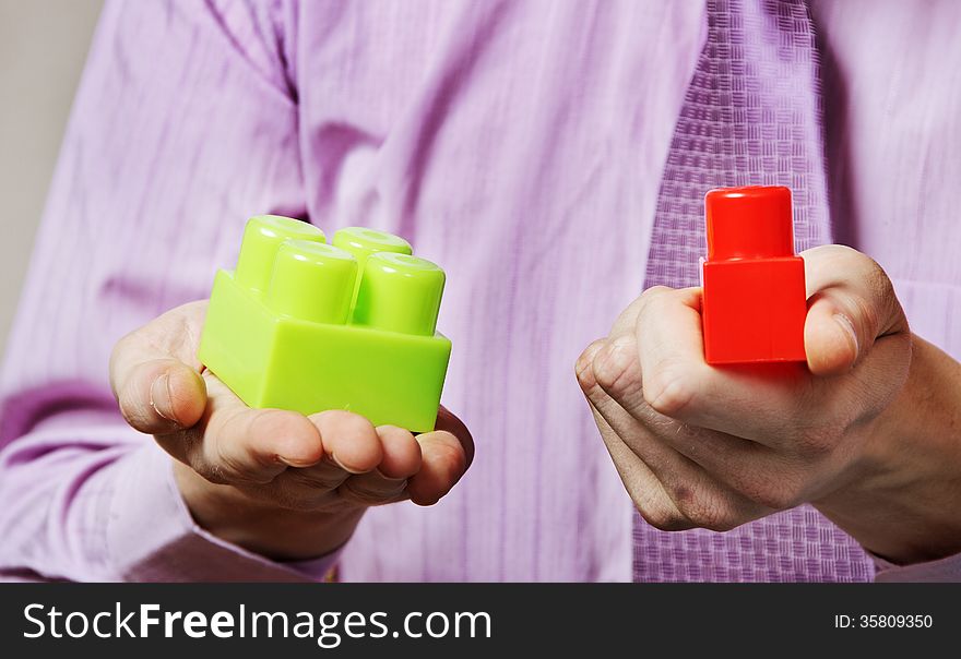Young man is playing with multicolored toy blocks. Young man is playing with multicolored toy blocks.