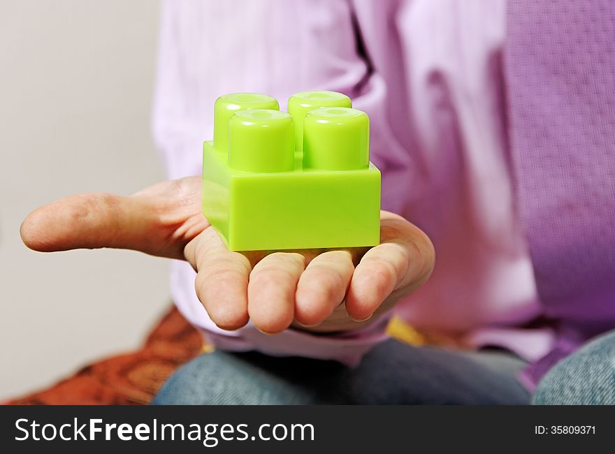 Young man is playing with multicolored toy blocks. Young man is playing with multicolored toy blocks.