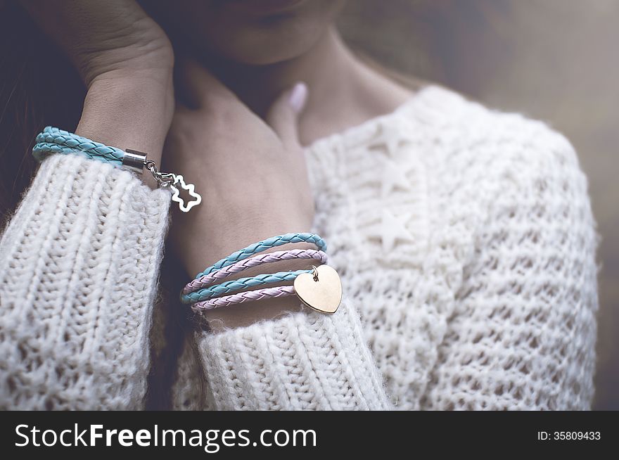 Young woman with silver jewelary on hand in white sweater. Young woman with silver jewelary on hand in white sweater
