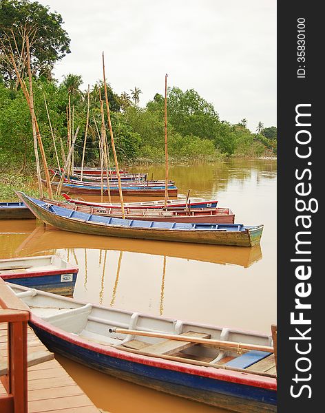 A scenery of boat at the lake with peaceful water and forest