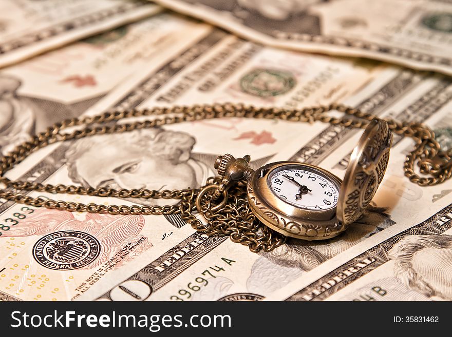 Pocket watch lie on dollars. watch and chain