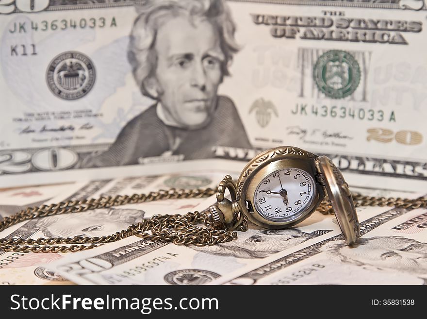 Pocket watch lie on dollars. watch and chain