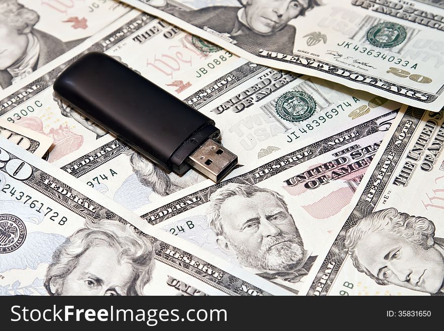 Usb flash drive lies on scattered dollars. Usb flash drive lies on scattered dollars