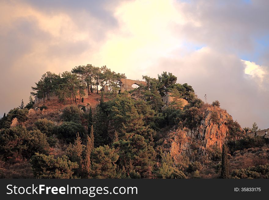 Ruins Of Medieval Castle On The Top Of The Hill Against Cloudy Sky