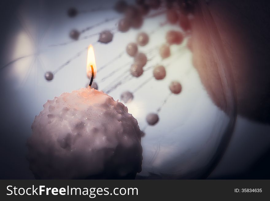 Small candle burning and melting like a snowball over abstract background. Small candle burning and melting like a snowball over abstract background.