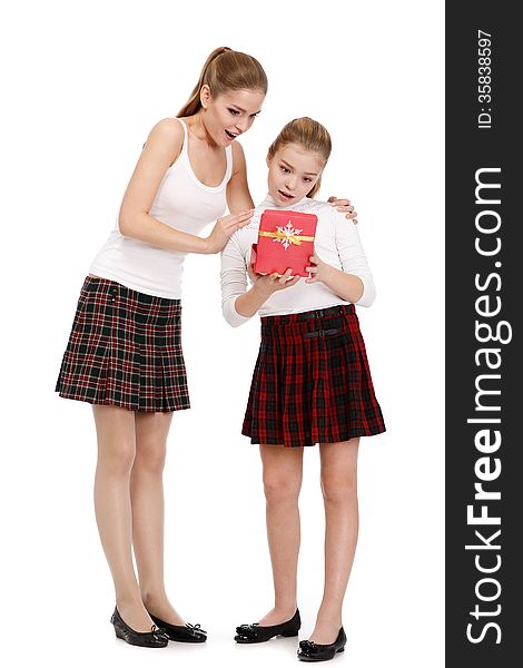 Portrait of sisters with a gift box on white background