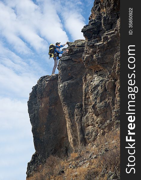 Man climbing on the rock on the outdoor sky