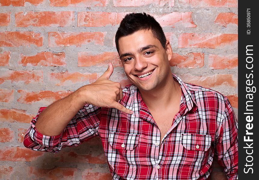 Smiling young man gesturing with hand. Smiling young man gesturing with hand.