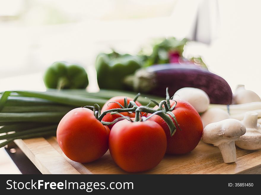 Homegrown organic produce on wooden cutting board outdoors. Homegrown organic produce on wooden cutting board outdoors