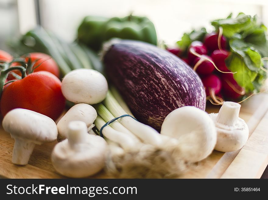 Homegrown organic produce on wooden cutting board outdoors. Homegrown organic produce on wooden cutting board outdoors