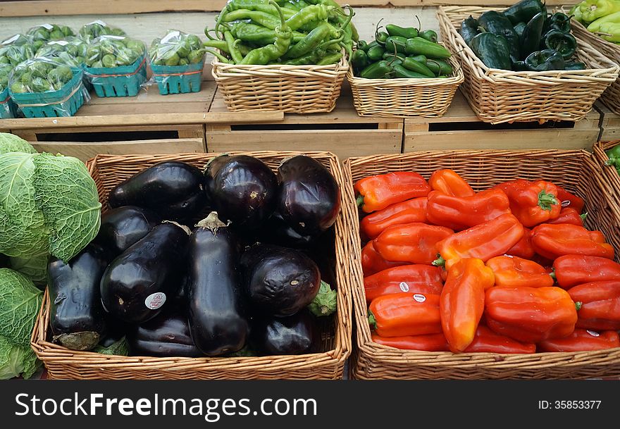 Fresh vegetables for sale at a farmers market: red, green, Serrano and habanero chili peppers, eggplant, cabbage and Brussels sprouts. Fresh vegetables for sale at a farmers market: red, green, Serrano and habanero chili peppers, eggplant, cabbage and Brussels sprouts.