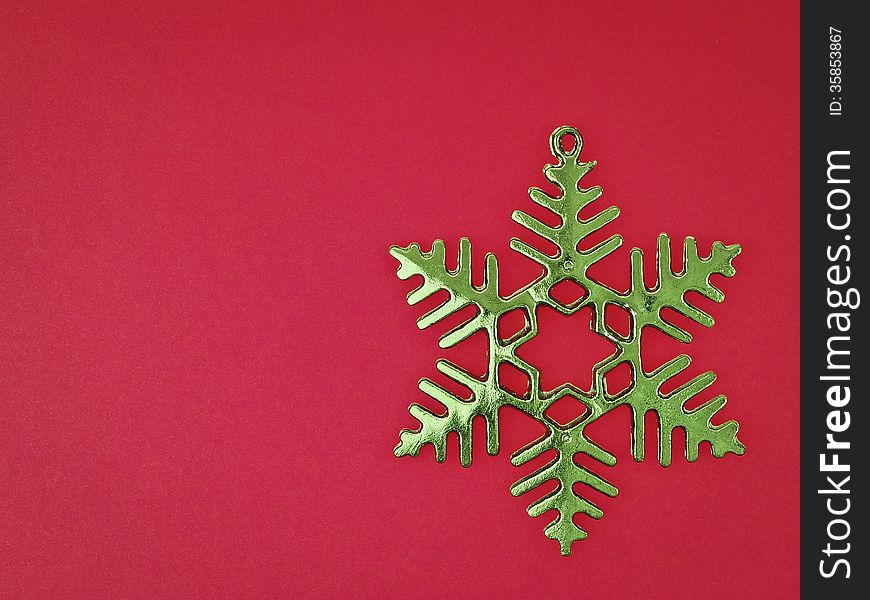 Ornament green snowflake on red background with copy space