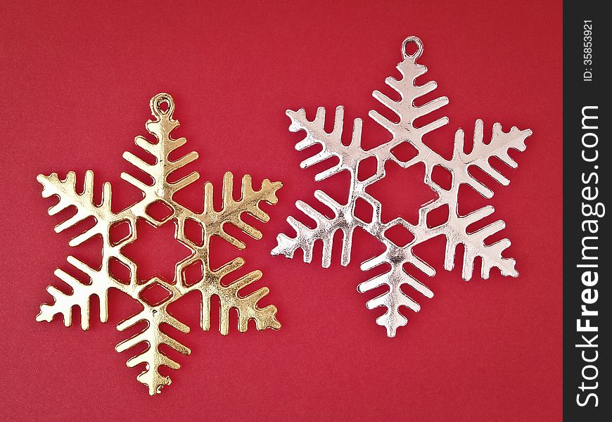 Pair of ornament gold and sliver snowflake on red background. Pair of ornament gold and sliver snowflake on red background