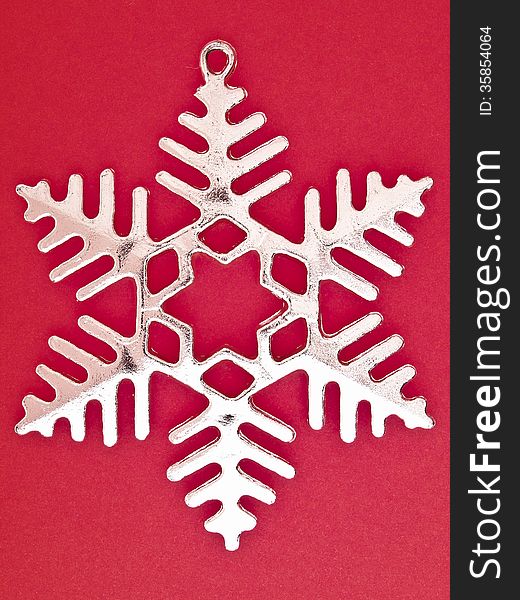 Ornament six pointed sliver snowflake on red background. Ornament six pointed sliver snowflake on red background