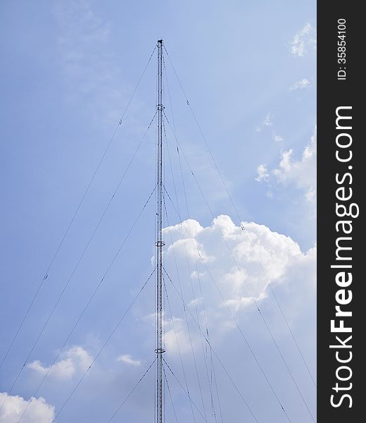 High communication pole on cloudy sky and sunlight