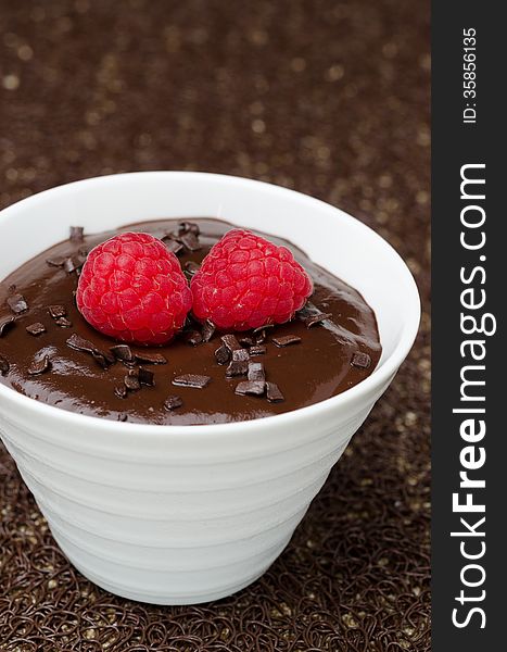 Close-up of chocolate mousse with fresh raspberries on dark background
