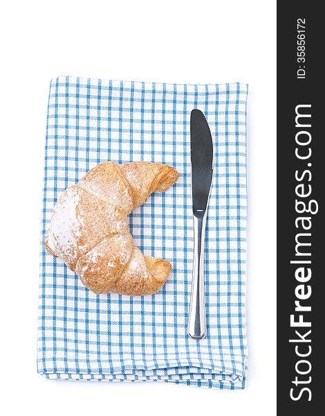 Croissant and a knife on a napkin, isolated